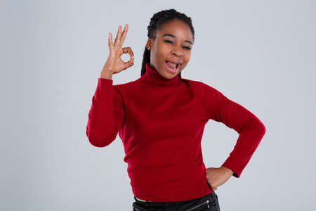 Emotional afro american girl showing a gesture ok and grimacing face.の写真素材