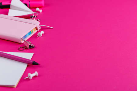 Pink notepad, pencils, markers and clips, on a pink background with a place for an inscription....