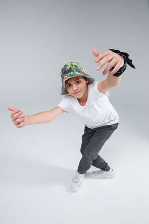 The active little guy dances cross-legged and raised his hands high. Top view.の写真素材