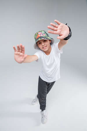 A cheerful little guy, actively dancing with his legs crossed and holding up his arms and smiling. Top view.の写真素材