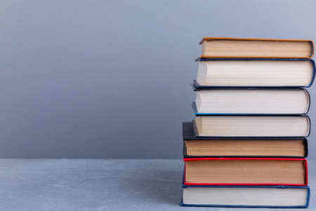 On the table there is a large pile of various books. With a place for an inscription.の写真素材