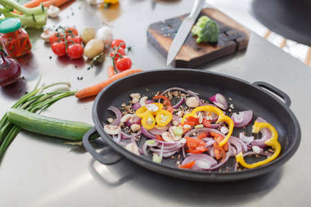The process of cooking vegetables in a kitchen room. Close-up of different ingredients for a healthy dish.の写真素材