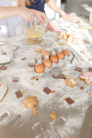 Products for baking cookies and cakes, preparation for baking. Flour with dough, eggs, eggshells, and biscuits on the kitchen table.の写真素材