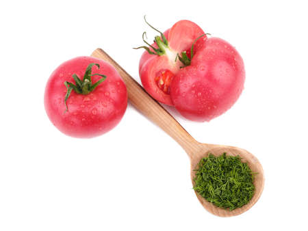 Bright red tomatoes with a wooden spoon full of dill isolated on a white background. Ripe, juicy and organic cherry tomatoes. Healthy vegetables.の写真素材