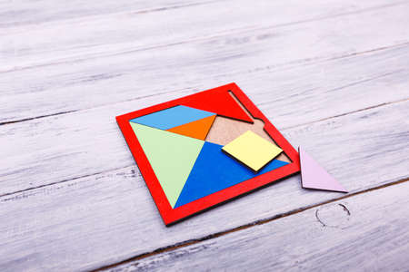 Educational games for children. Red, yellow, pink, blue geometrical figures on the wooden background. Entertaining objects. Close-up. Entertainment concept.の写真素材