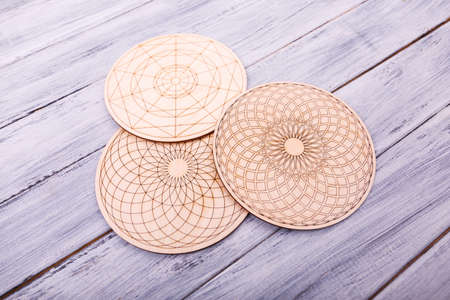 Big interest round cardboard stencils for drawing with geometrical figures. Enthusiastic scientific cards for children on the wooden background. Close-up. Entertainment concept.の写真素材