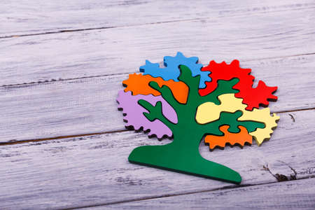 Intellectual games for children. Multicolored tree for playing. Pink, red, yellow, green, purple, orange trees details on the light wooden background. Copy space. Close-up.の写真素材