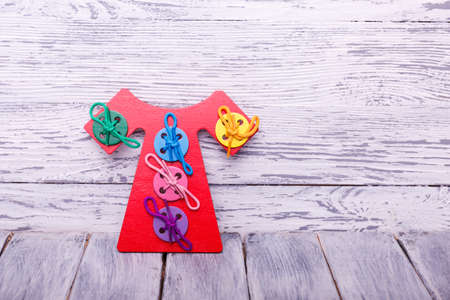 Educational games for children. Red, yellow, pink, blue geometrical figures on the wooden...