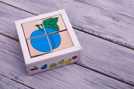 Educational wooden toys for children. Colorful figures on the wooden background. Ecological wooden cubes with different fruits.の写真素材