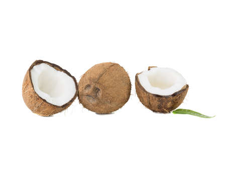 A close-up picture of chopped in half and whole coconuts isolated on white background. The concept of exotic fruits with leaves full of vitamins.の写真素材