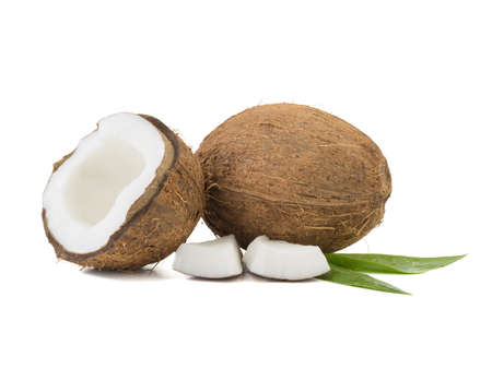 A close-up picture of chopped in half and whole coconuts isolated on white background. The concept of exotic fruits with leaves full of vitamins.の写真素材