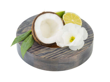 A close-up picture of chopped in half coconut and lime with a flower isolated on white background. The concept of tropical fruits with leaves full of vitamins.の写真素材