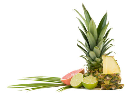 A composition of exotic and tropical fruits with leaves isolated on a white background. A sliced pineapple, lime pieces, halved cut grapefruit and passionfruit.の写真素材