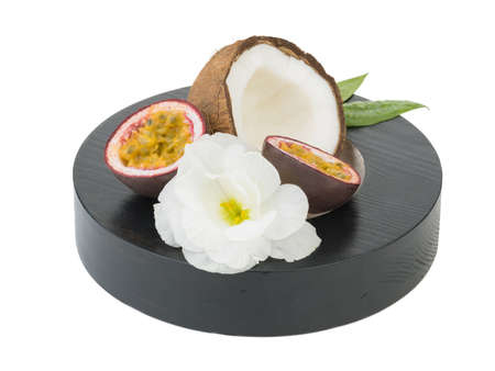 A close-up picture of chopped in half coconut and lime with a flower isolated on white background. The concept of tropical fruits with leaves full of vitamins.の写真素材