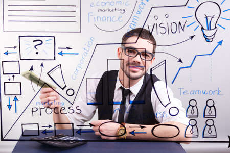 A successful and concentrated young businessman counting money in the office. Business presentation conceptの写真素材