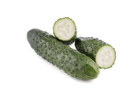 A group of whole and halved cucumbers isolated on white background, close up. The concept of ripe and fresh vegetables.の写真素材