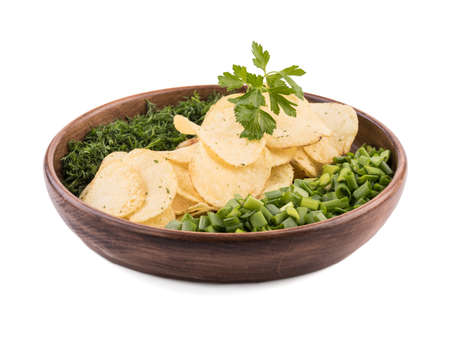 Closeup of crispy potato chips with fresh greens in a brown plate on a white background. Junk food concept. Top view of a fast snack.の写真素材