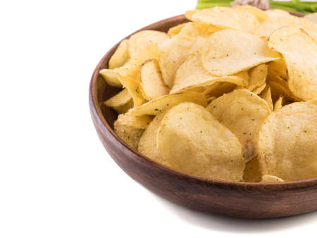 Closeup of crispy potato chips in a brown plate on a white background. Junk food concept. Top view of a fast snack.の写真素材