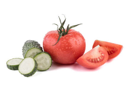 A fresh vegetables isolated on a white background. A group of sliced green cucumbers, juicy and red tomatoes. Ingredients for saladの写真素材