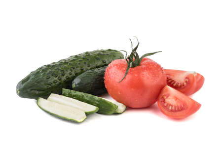 A fresh vegetables isolated on a white background. A group of sliced green cucumbers, juicy and red tomatoes. Ingredients for saladの写真素材
