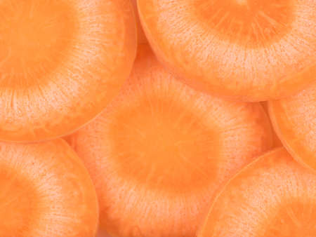 Top view of fresh and organic sliced orange carrot as a background. The concept of healthy...