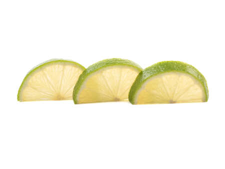 Green slices of ripe and fresh lime isolated on white background. A concept of citrus fruits full of vitaminsの写真素材