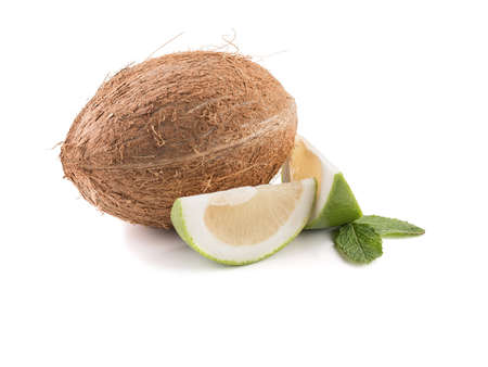 Sliced lime, grapefruit and a whole coconut isolated on a white background. A concept of exotic fruits full of vitaminsの写真素材