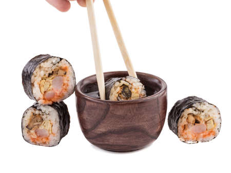 A set of sushi rolls with chopsticks and soy sauce isolated on white background. A concept of seafood and Japanese cuisine.の写真素材