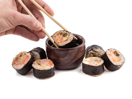A set of sushi rolls with chopsticks and soy sauce isolated on white background. A concept of seafood and Japanese cuisine.の写真素材