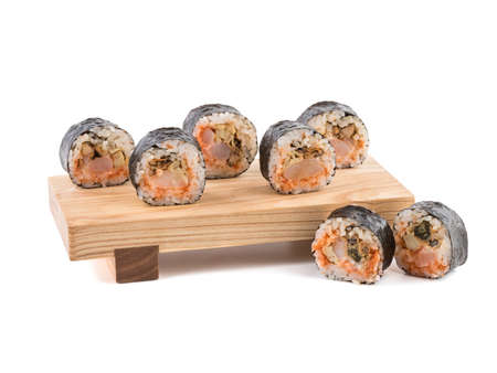 A set of sushi rolls on a wooden board isolated on white background. A concept of seafood and Japanese cuisine.の写真素材