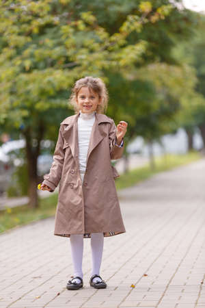 A pretty little girl in an autumn coat in the park. Autumn concept.の写真素材