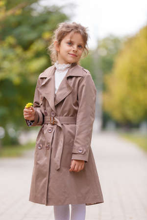 A pretty little girl in an autumn coat in the park. Autumn concept.の写真素材