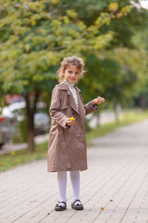 A pretty little girl in an autumn coat in the park. Autumn concept.の写真素材