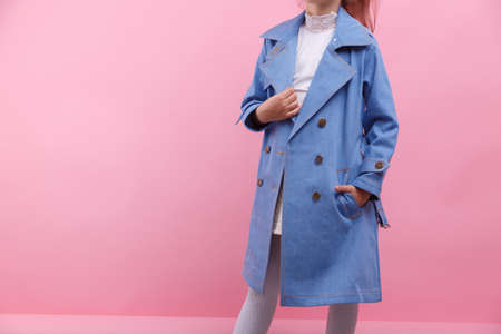 A body of a schooler girl in a blue denim coat on a bright pink background, close-up. Fall and spring children's fashion concept.の写真素材