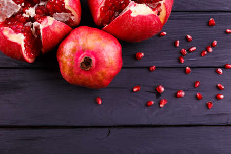 The sweet, fresh and natural garnet for desserts and beverages on a black background. Bright red pomegranate broke down into partsの写真素材