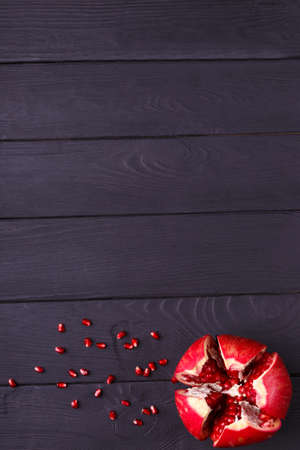 A top view of a red garnet. Healthy sour pomegranate on a black background. A garnet piece full of juicy, fresh, tasty seeds.の写真素材