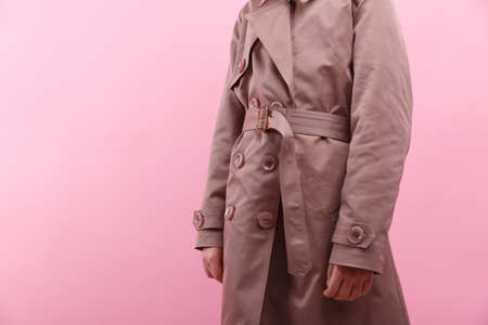 Body of a little girl in an autumn coat on a bright pink background. Fall and Spring children's fashion concept.の写真素材