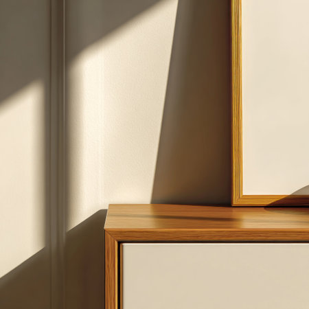 Close-up of framed artwork and a cabinet, bathed in soft light and shadowの素材