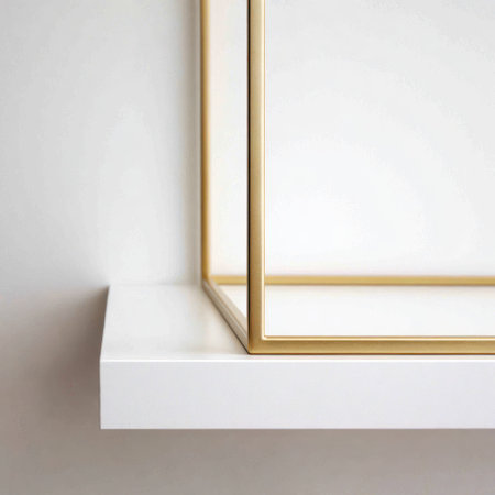 Minimalist shot of a white floating shelf with a gold metal frame detail against white wallの素材