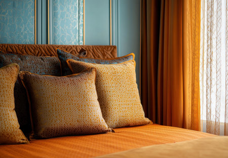 A close-up shot of an orange and brown bed with pillows, against a wall painted in a light blue color. The room also features curtains with a patterned amber tulle on them. A window is visible on the right side, adding to the warm ambiance. This scene captures intricate details that highlight textures like soft fabric and patterns. --ar 43:30 --v 6.1 Job ID: 42725667-e28d-41c5-a770-ca6b2e77f44fの素材