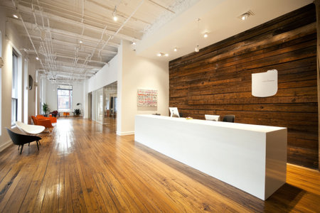 Modern office interior with a white reception desk, wood flooring, and wall panels. --ar 3:2 --v 6.1 Job ID: 6a393d8a-a4c7-4fac-9675-bdbb9e790c8eの素材