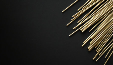 A flat lay of thin brass rods scattered on the right side, against a black background. The composition is minimalist and modern with clean lines. --ar 26:15 --v 6.1 Job ID: 8b6c0fb1-1e81-4856-96ea-18bb0641abb7の素材