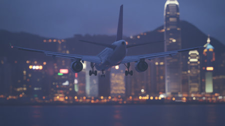 Realistic stock-style, high-resolution photograph of an airplane flying over a city, taken from behind with a bokeh effect in the background. The plane is white and has black wheels, flying above water at dusk. In front of it, blurred lights create bokeh effects on the buildings along its path. This shot should capture the motion blur of the flight as well as the silhouette against the twilight sky. --chaos 30 --ar 16:9 --v 6.1 Job ID: 51c0dd67-d5e9-43f5-b779-3f9f4d0fa7aeの素材