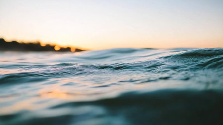 A close-up of the surface of an ocean, with light blue water and blurred sunlight in the background. The focus is on gentle ripples in the sea's texture, creating a serene and tranquil atmosphere. This scene captures the beauty of nature's vastness through its soft lighting and tranquil mood. --chaos 30 --ar 16:9 --v 6.1 Job ID: 8825db5e-d39e-45b5-8453-a93a7a7f6136の素材