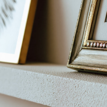 Close-up of framed art pieces on a textured, neutral-toned shelfの素材