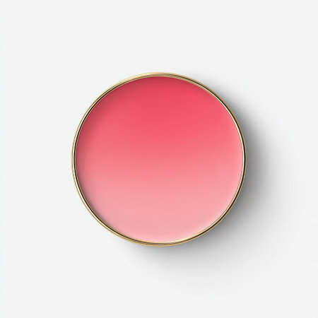 Overhead shot of a circular blush compact with a pink to light pink gradient, golden rimの素材