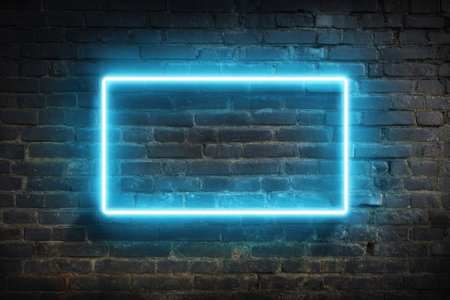 A glowing blue rectangular neon light fixture against a weathered, dark brick wallの素材