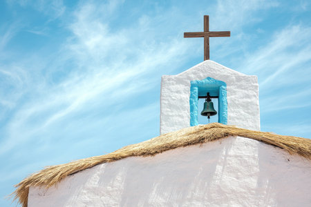 Photograph of a white and blue church in the Atacama Desert, Chile, with a wooden cross on the roof, a bell tower, adobe walls, and thatched straw domes outside, against a blue sky. --ar 3:2 --v 6.1 Job ID: 43799620-9d01-42bd-a813-24cdf3b35b24の素材
