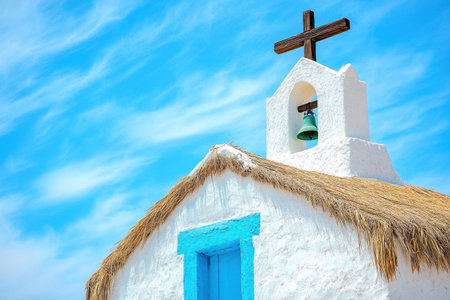 Photograph of a white and blue church in the Atacama Desert, Chile, with a wooden cross on the roof, a bell tower, adobe walls, and thatched straw domes outside, against a blue sky. --ar 3:2 --v 6.1 Job ID: 43799620-9d01-42bd-a813-24cdf3b35b24の素材
