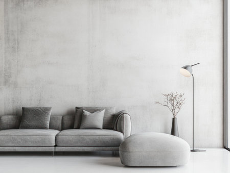 A modern minimalist interior design with a concrete wall, white floor, and a grey sofa. The room has one lamp on the right side. There is also an ottoman in front of the couch. A vase stands next to it. A minimalist style with clean lines. --ar 4:3 --v 6.1 Job ID: 758b570a-286f-4989-b968-519f5b986bc7の素材